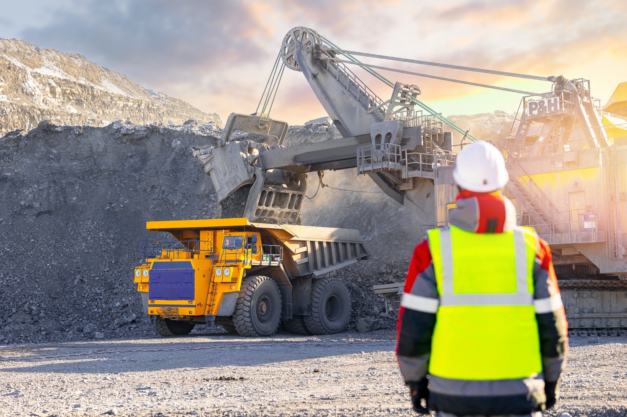 Coal mining site with workers and excavators operating heavy equipment