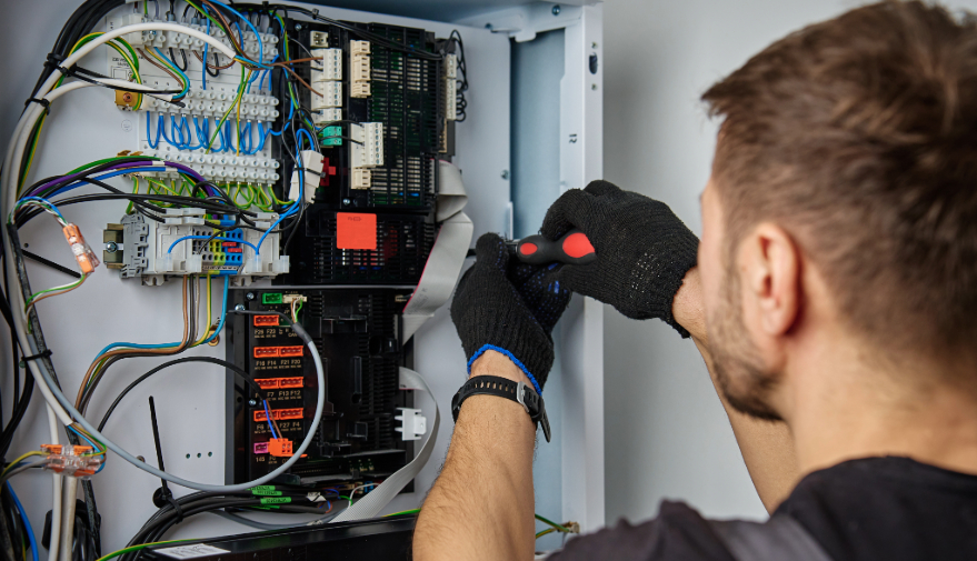 HVAC engineer working on internal wiring of heat pump, inspecting electrical connections