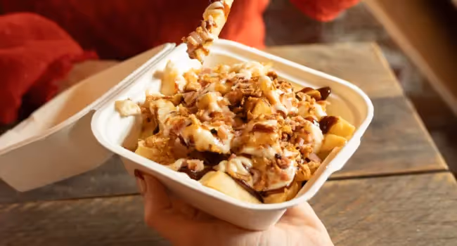 Loaded Spud Fries: topped with BurgerFuel Aioli, BBQ and cheese sauces, bacon bits, and crispy onion.