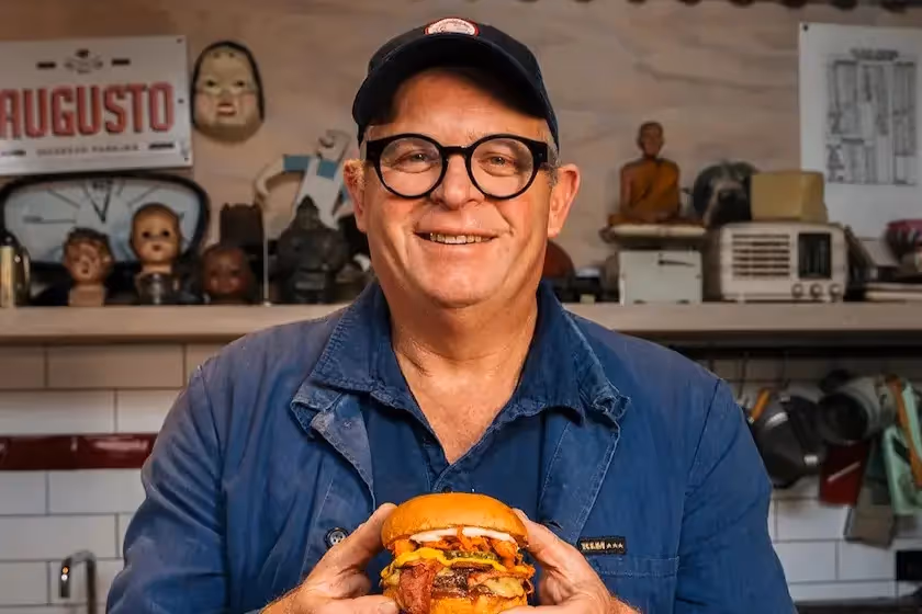 The Mustang Deli: a bold burger–Reuben mashup with grass-fed NZ beef, deli pastrami, Old Yella mustard, cheddar, pickles, and tangy kimchi in a soft pretzel bun. Created with Al Brown.