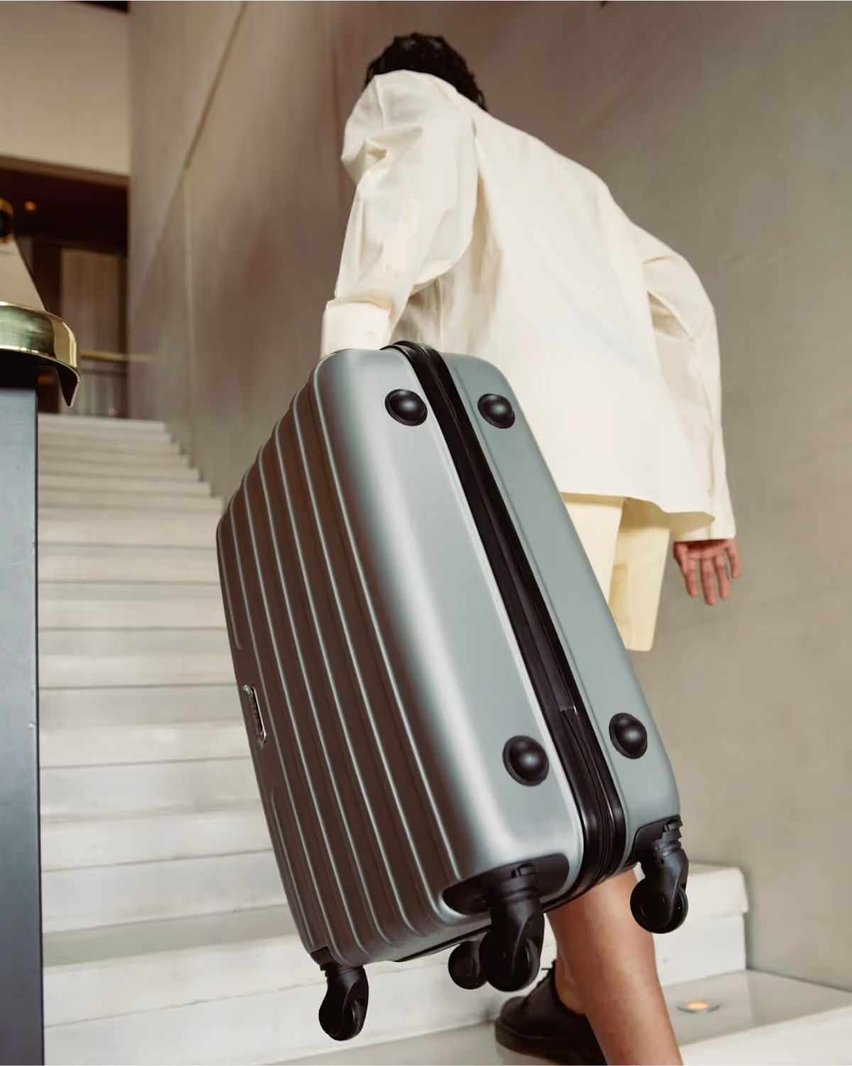 Image of a person carrying their luggage up the stairs