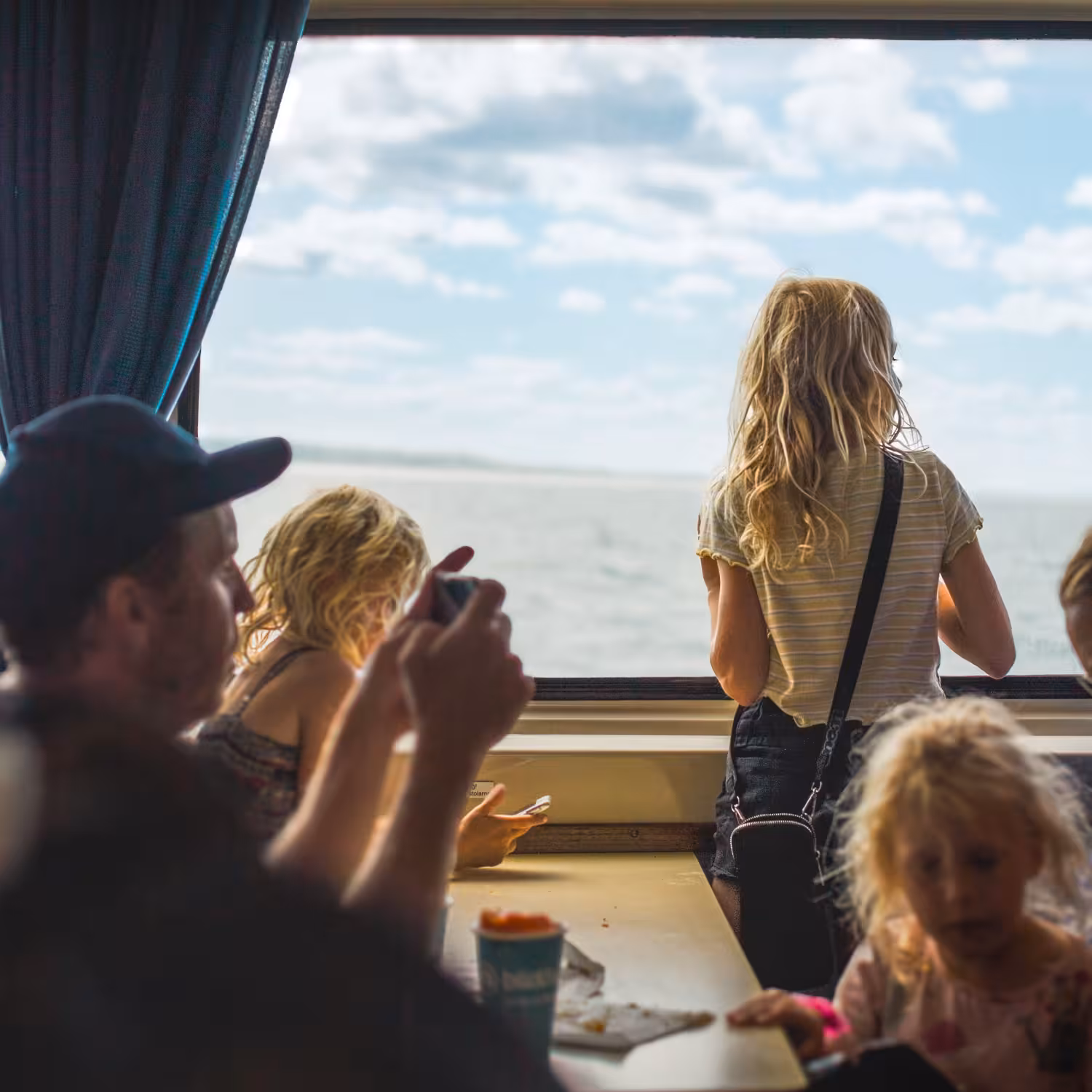 family with kids travelling and looking out a ship window