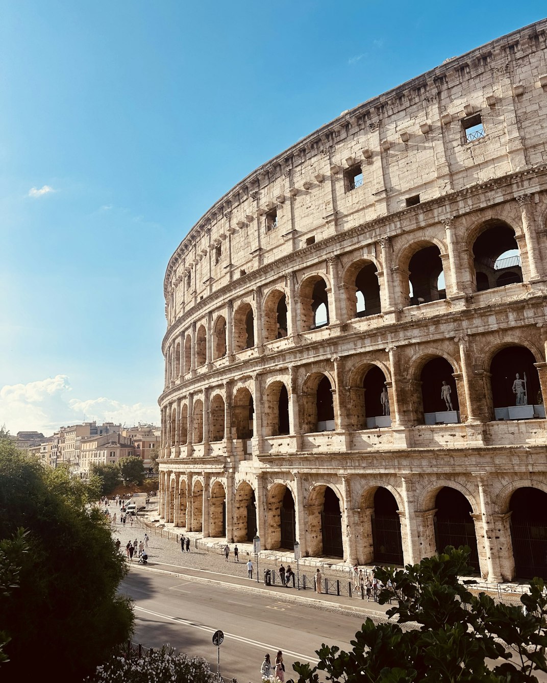 The Colosseum in Rome under a bright blue sky