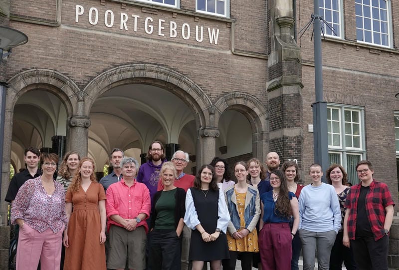 A team photo of the Medilingua team, showing 20 of the team members stood out side the Poortgebouw building.
