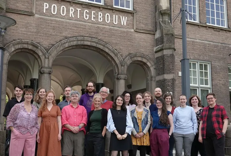 A team photo of the Medilingua team, showing 20 of the team members stood out side the Poortgebouw building.
