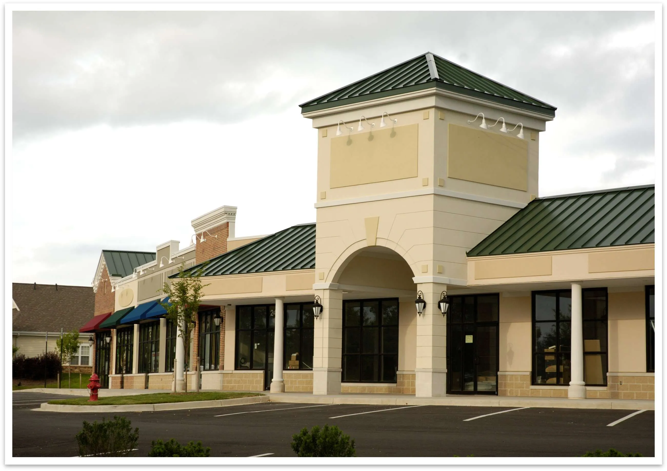 Commercial building with a green roof and storefronts, suitable for retail space leasing.
