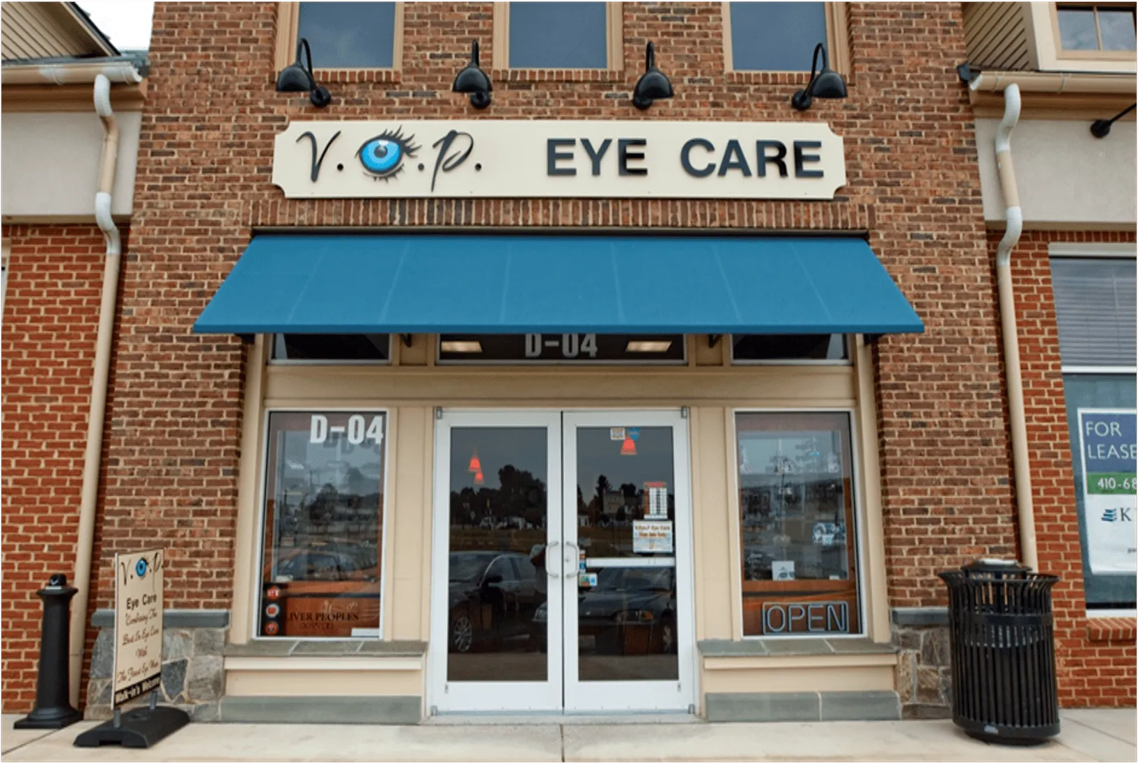 V.O.P. Eye Care features a welcoming storefront with an open sign in a brick building.
