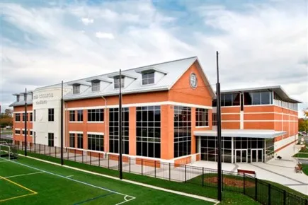 The modern sports facility features a brick exterior and large windows, ideal for athletic events and activities.