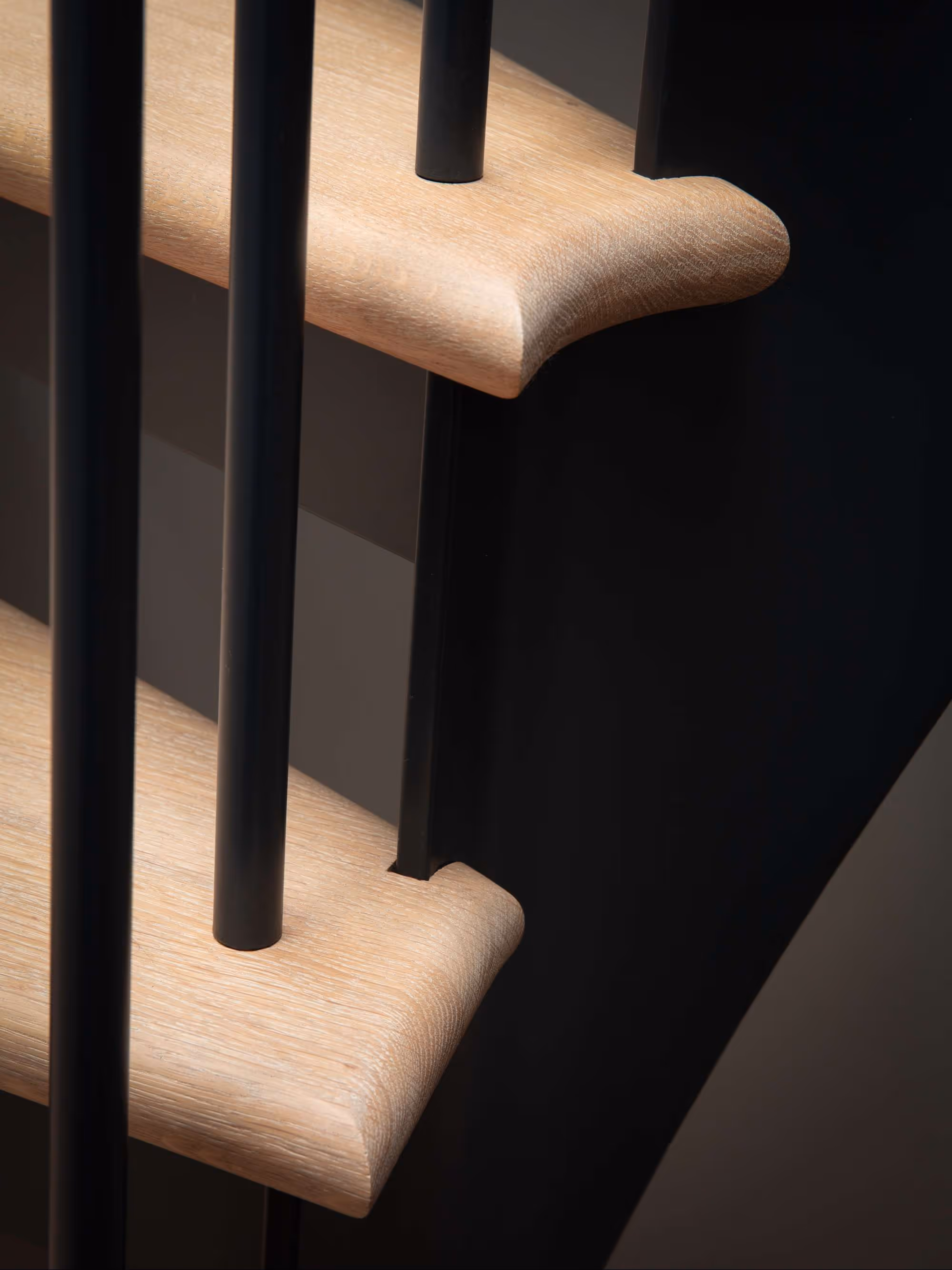 bespoke, curved, pale oak tread, metal staircase with black metal spindle balustrade