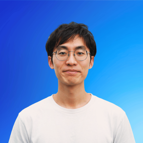 Porträt eines jungen Mannes mit schwarzen Haaren und Brille vor einem blauen Verlaufshintergrund.