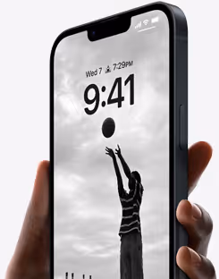 Hand holding a smartphone showing a black and white lock screen image of a child reaching to catch a ball under a cloudy sky.