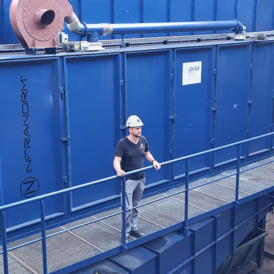 Ein Arbeiter steht auf einem blauen Gelände