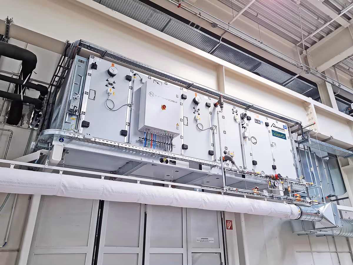 Two Infranorm workers work on the roof of a building