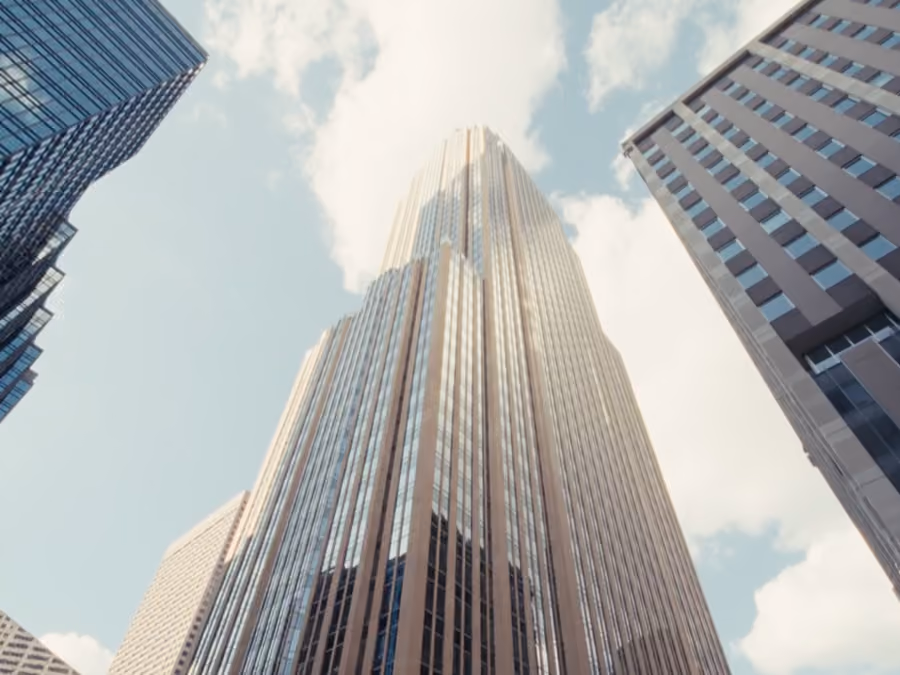 View looking up at tall glass and steel skyscrapers against a blue sky with clouds.