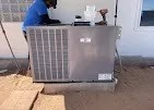 Technician inspecting AC coils and filters during a tune-up