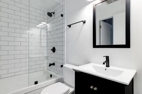 A beautiful bathroom closeup of shower, sink, mirror and toilet
