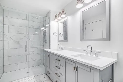 A bathroom with light gray and white tones