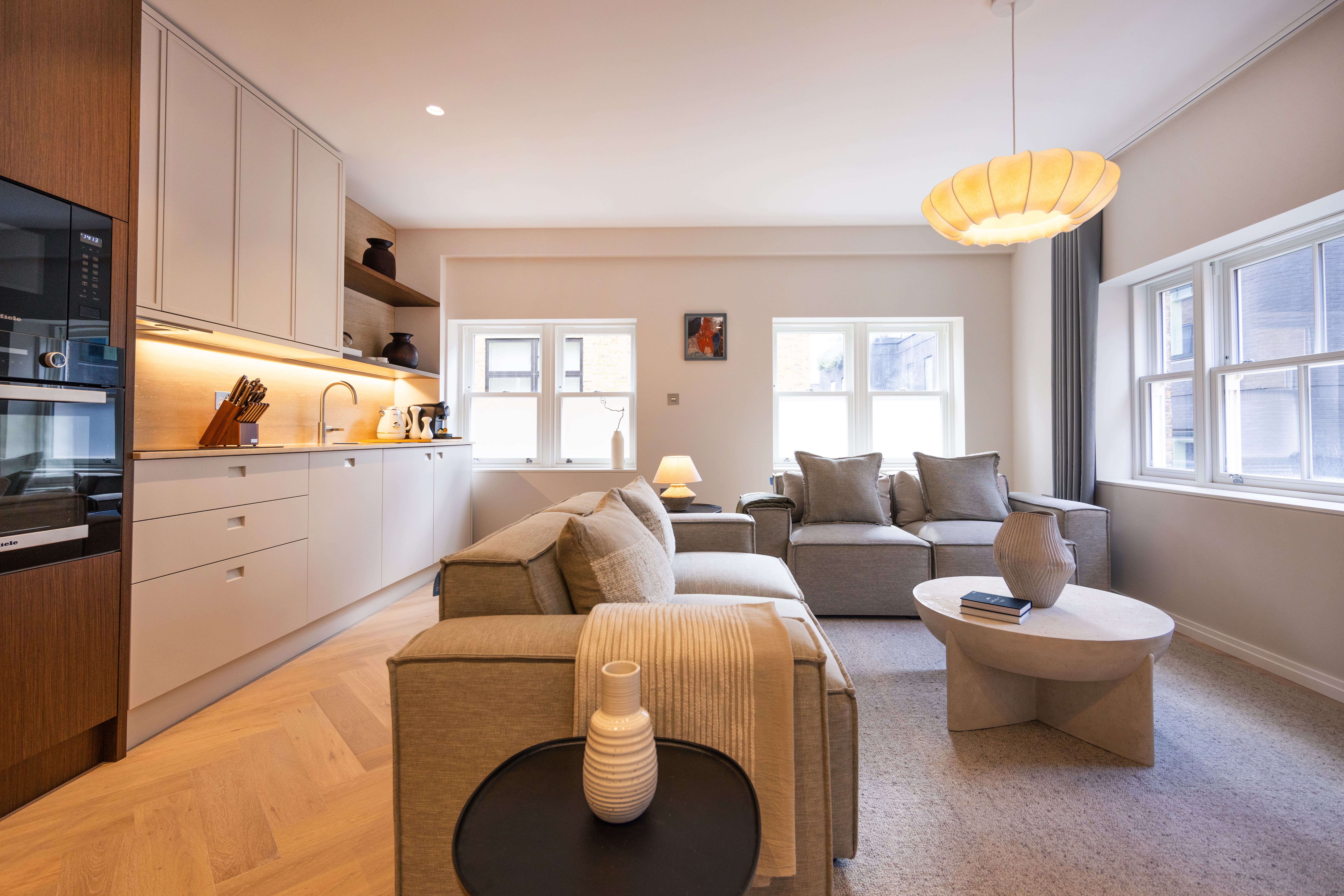 A bright London apartment with a furnished living area and warm wood kitchen