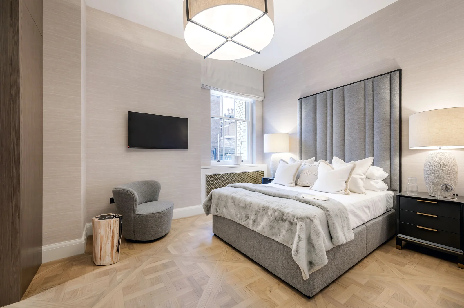 A calm London bedroom with considered lighting and furnishings