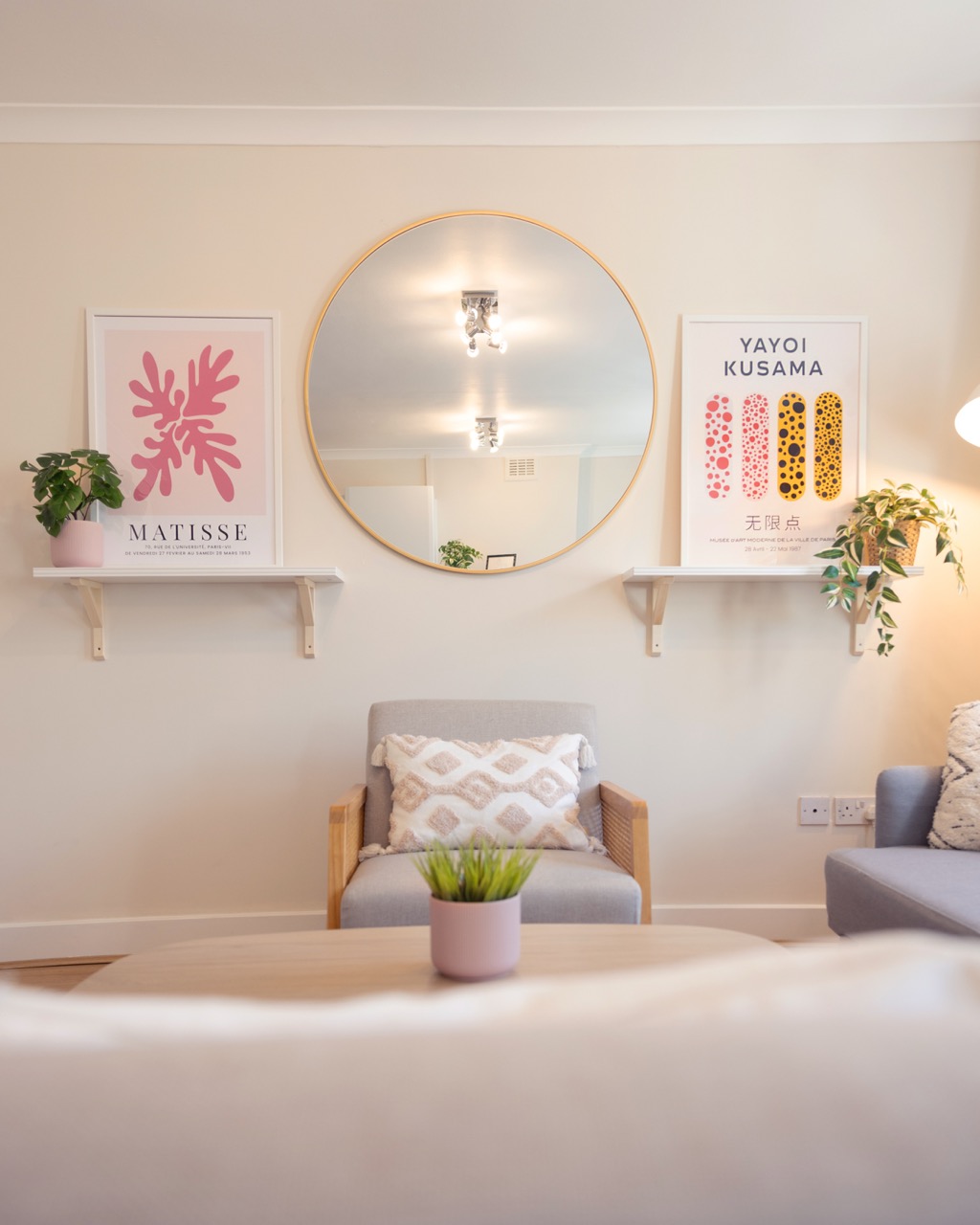 A thoughtfully furnished living room with comfortable seating, artwork and natural light