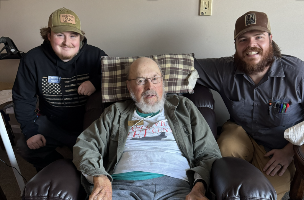 Legette Zorn sits in his new electric armchair. Beside him are Maintenance Technicians Kellen Cody and Ethan Bolick.