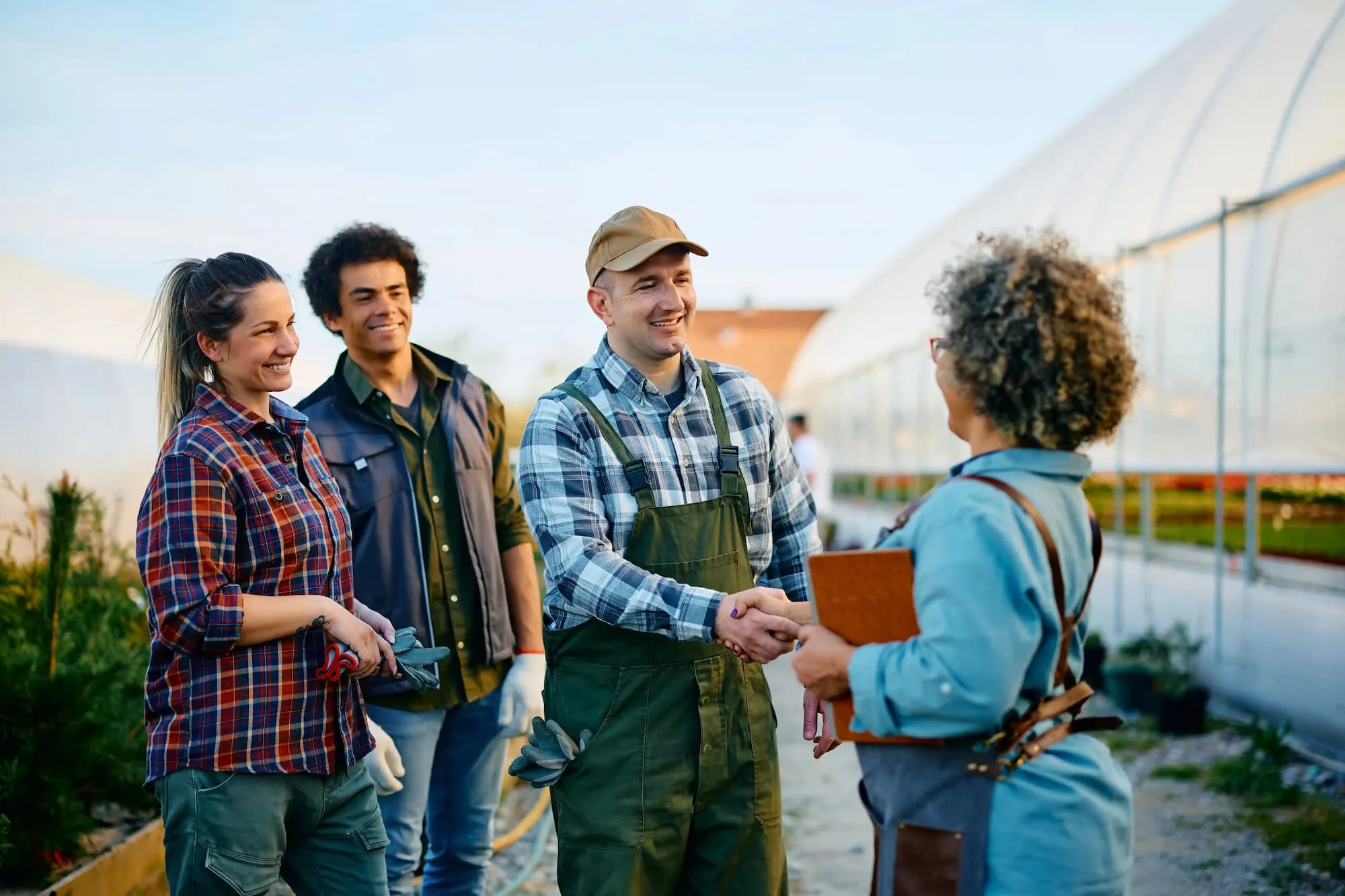 happy farmers shaking hands with woman