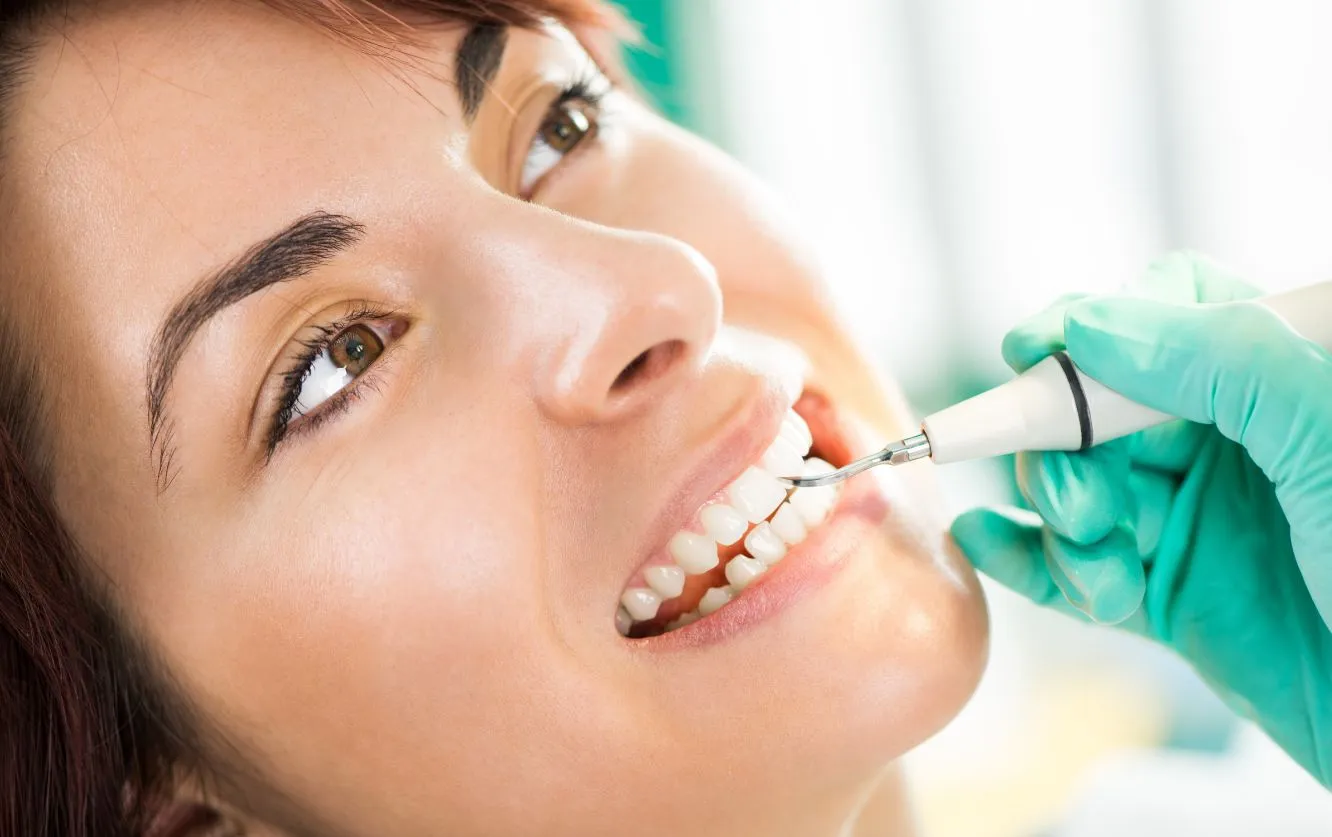 Close-up of a cheerful woman showing off her bright, healthy smile after a cosmetic dental treatment like whitening