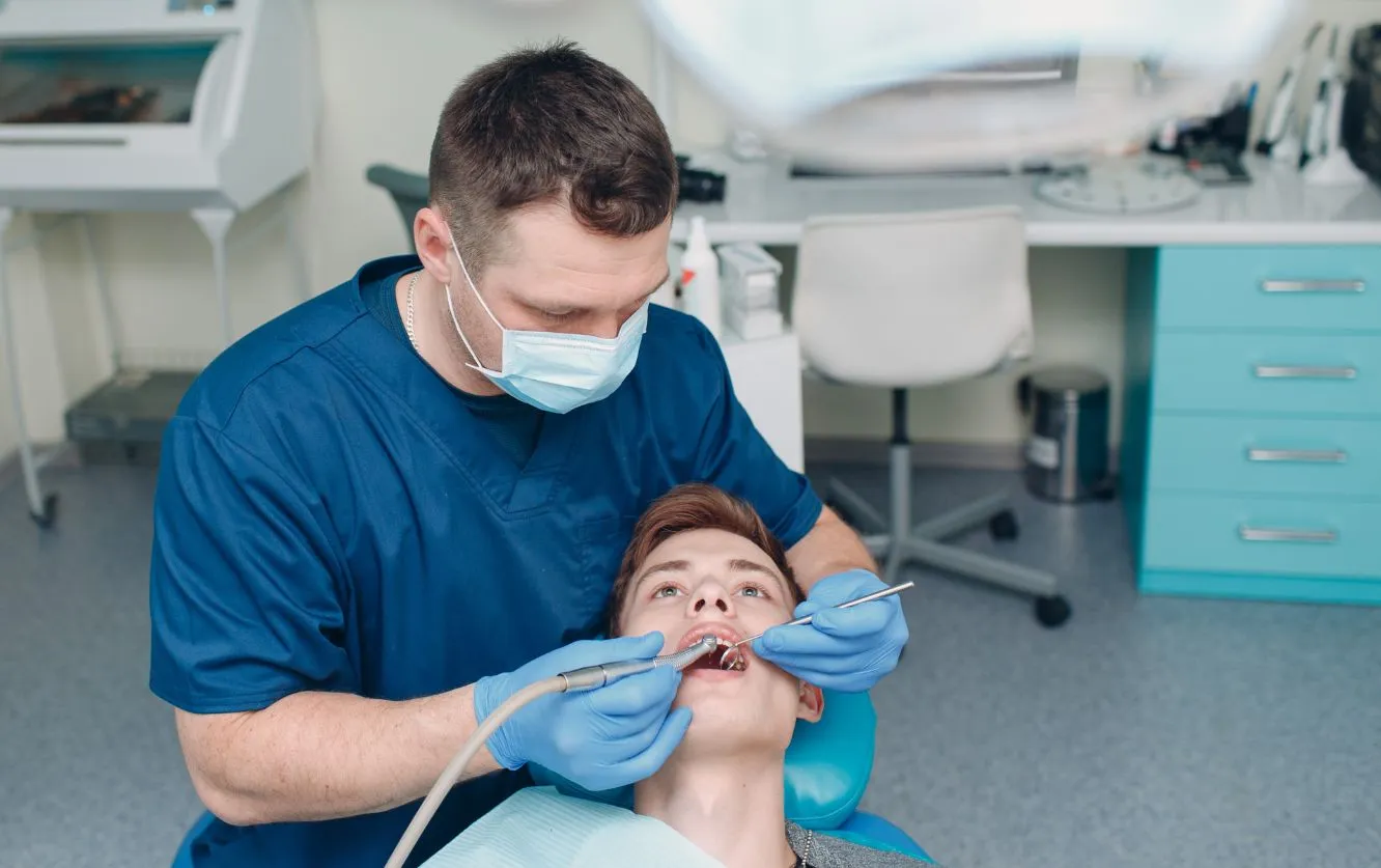 Dental technician or assistant using precision tools to adjust a dental mold or appliance, representing behind-the-scenes lab work essential to creating custom restorations