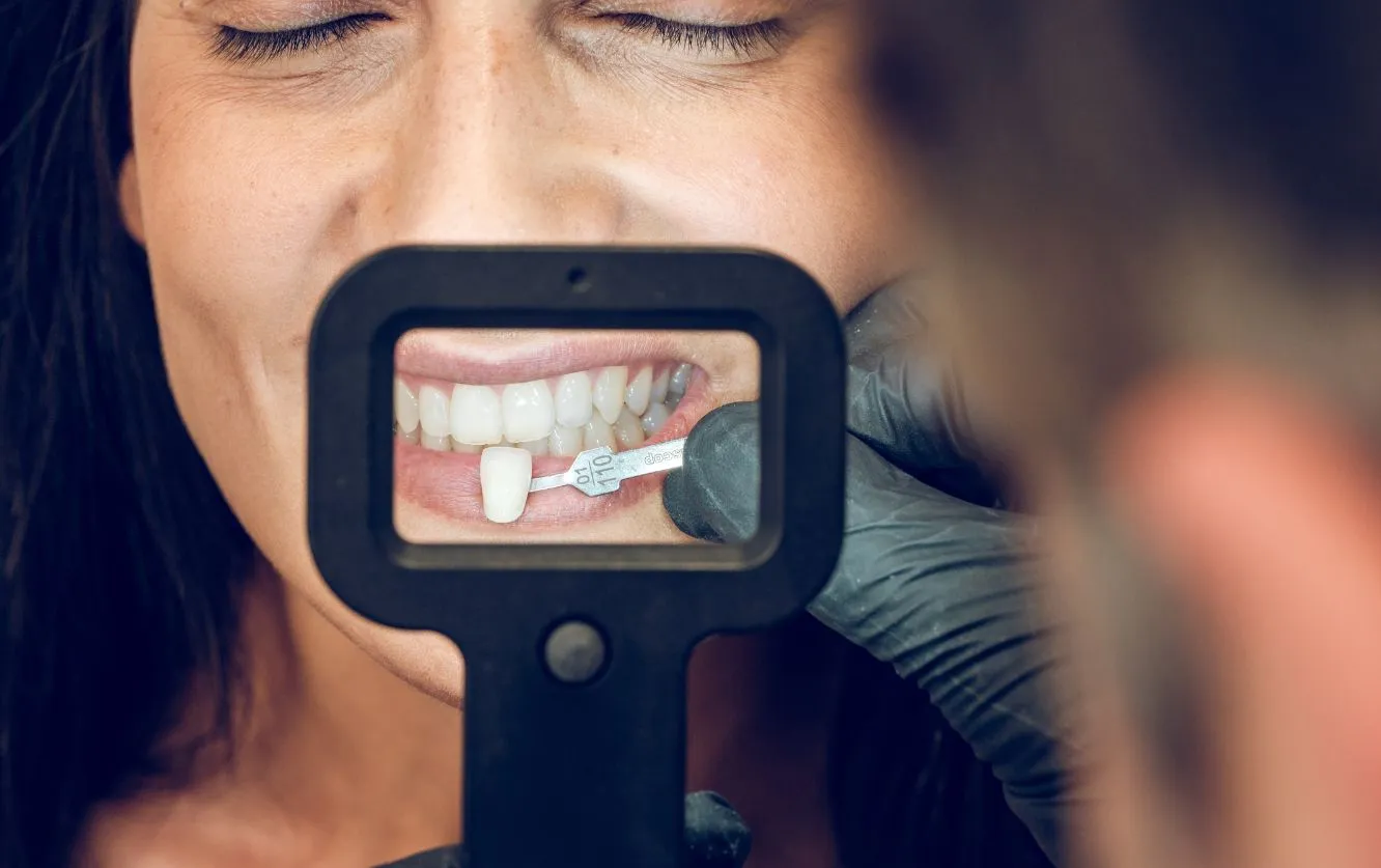 Close-up of intraoral camera being used by a dental professional to show a patient real-time images of their teeth and gums during a comprehensive dental examination
