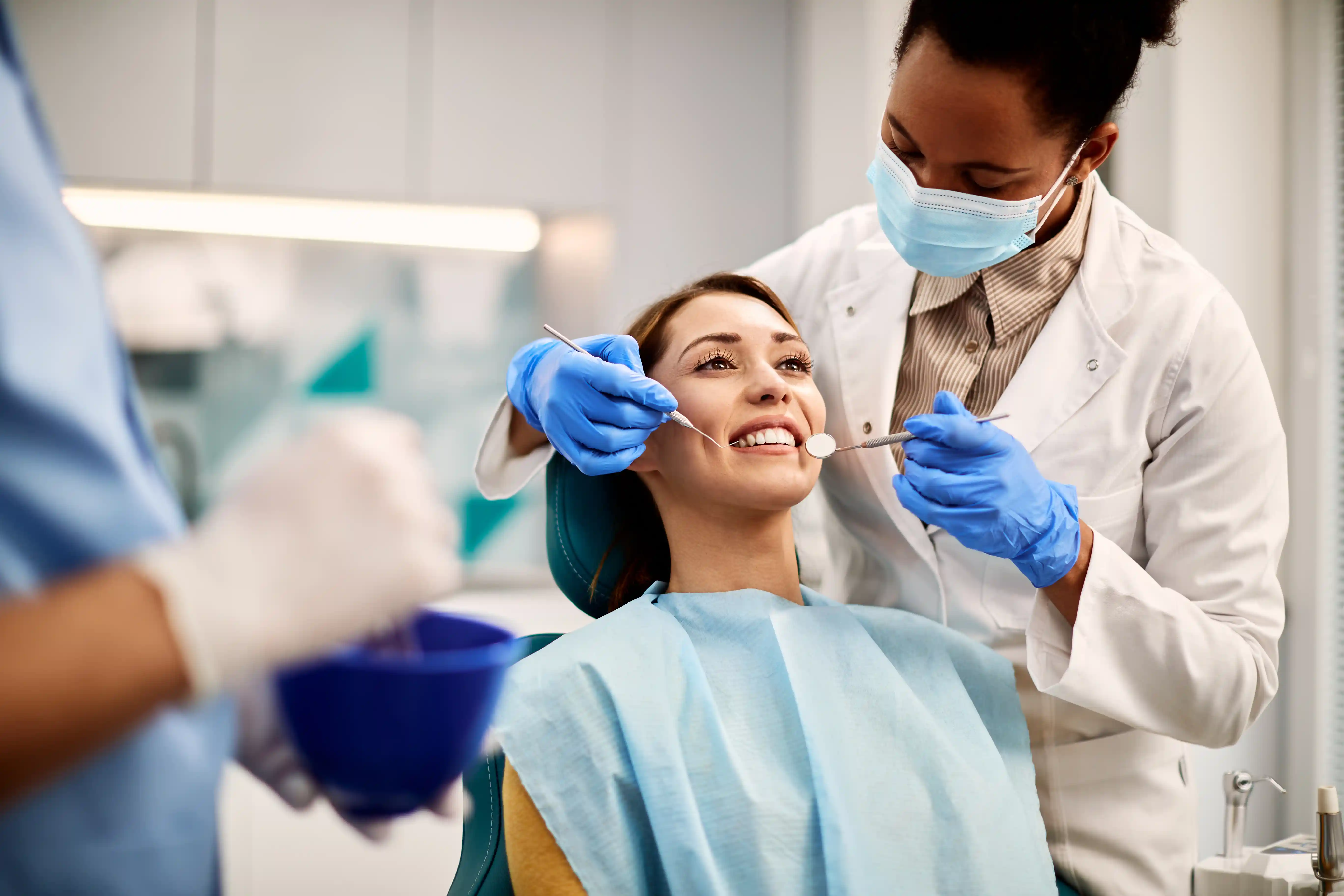 Female patient smiling during a comprehensive dental exam performed by a gentle and experienced family dentist near me in Lathrup Village, Michigan