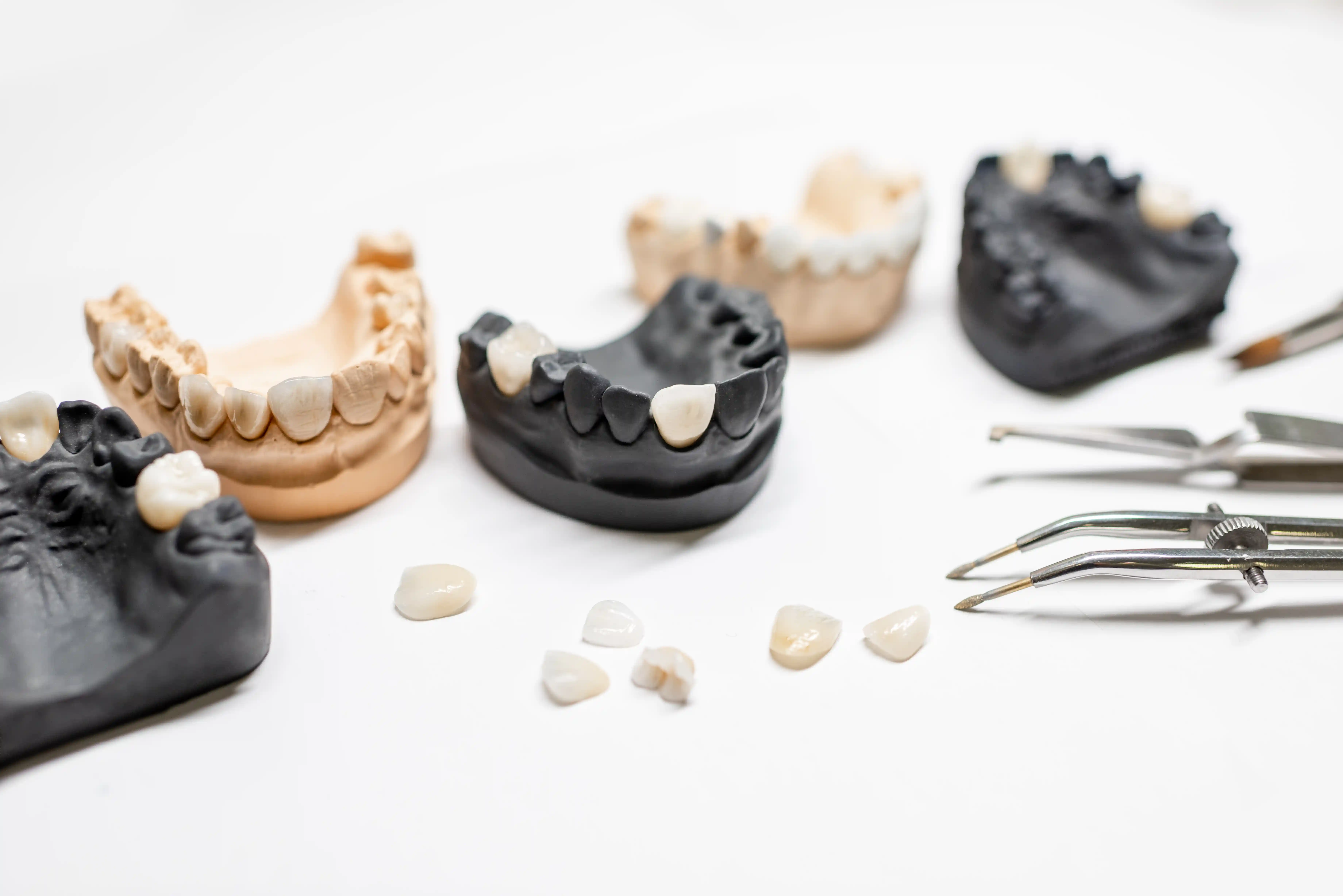 Custom dental crowns and bridges displayed with professional dental tools – restorative dentistry services by a dentist near me in Lathrup Village, MI