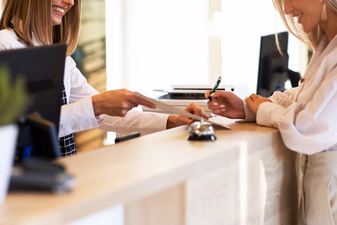 Receptionist assisting consumer at the front desk.