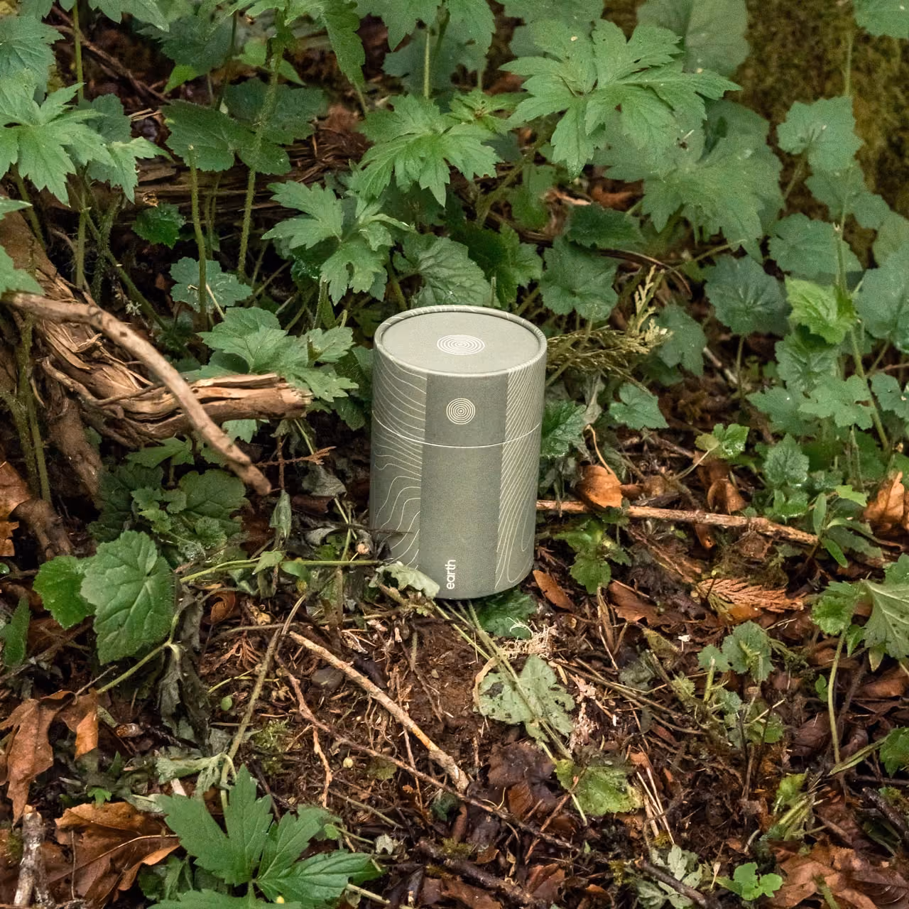 Earth Funeral soil transformation vessel placed on natural ground, square crop