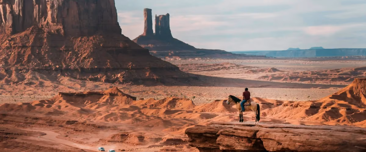 Desert landscape of Arizona with a man horseback riding in the distance