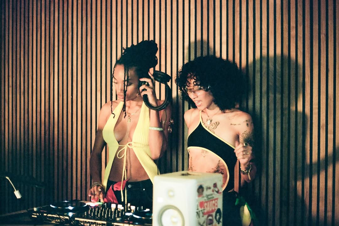 Demi and Jacey of Mix Signals are Dj's an event with a warm light hitting them for this artist portrait.