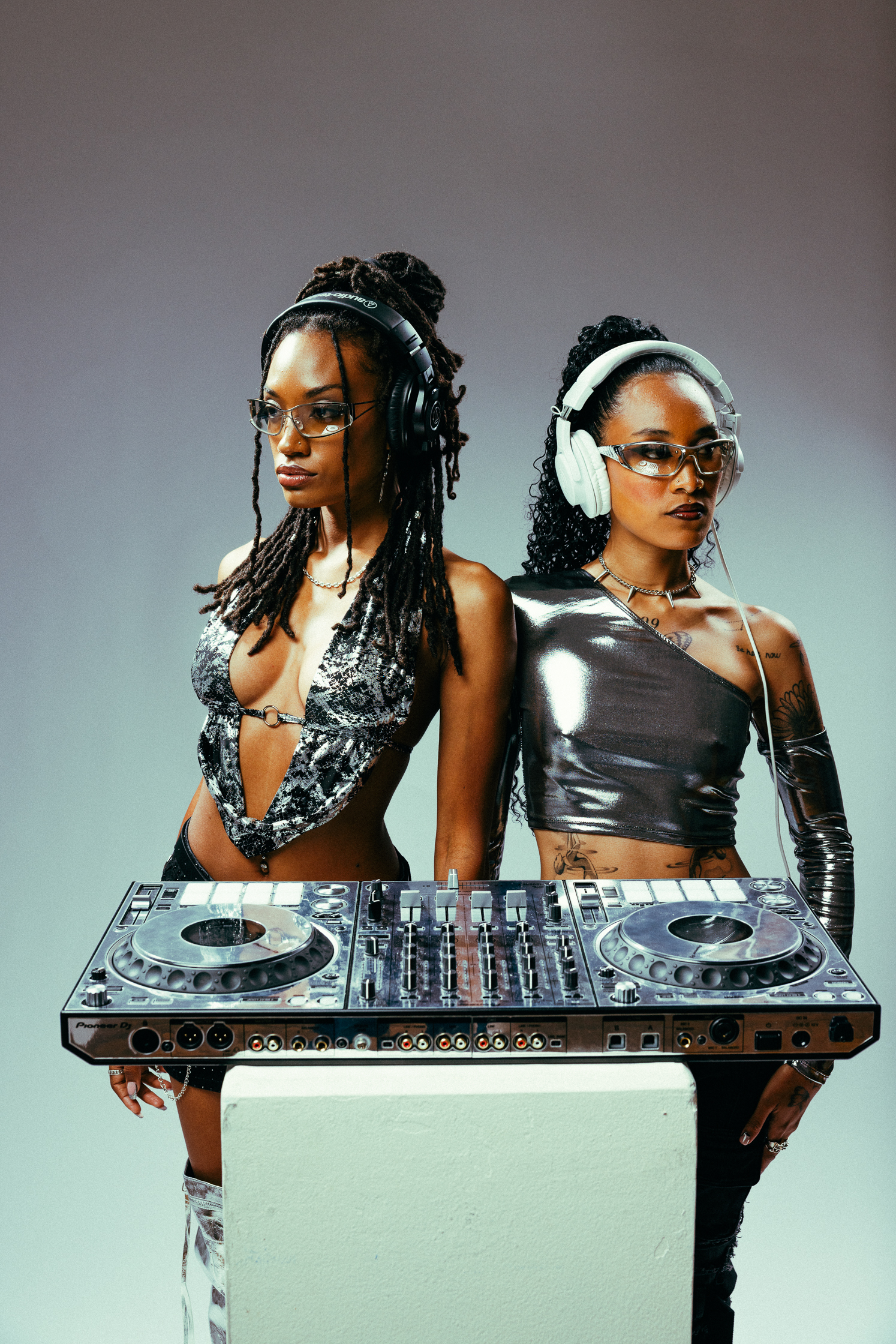 Mix Signals stand styled in a futuristic look infront of a CDJ