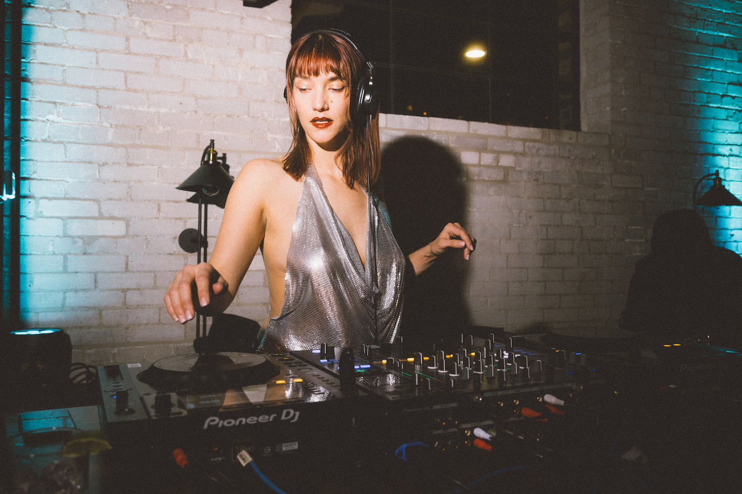 Murderith is light up but a bright flash with the Mexico City skyline in the background in this artist portrait.