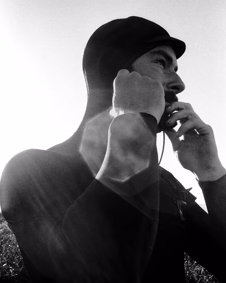 Man in wetsuit, backlit by bright sky