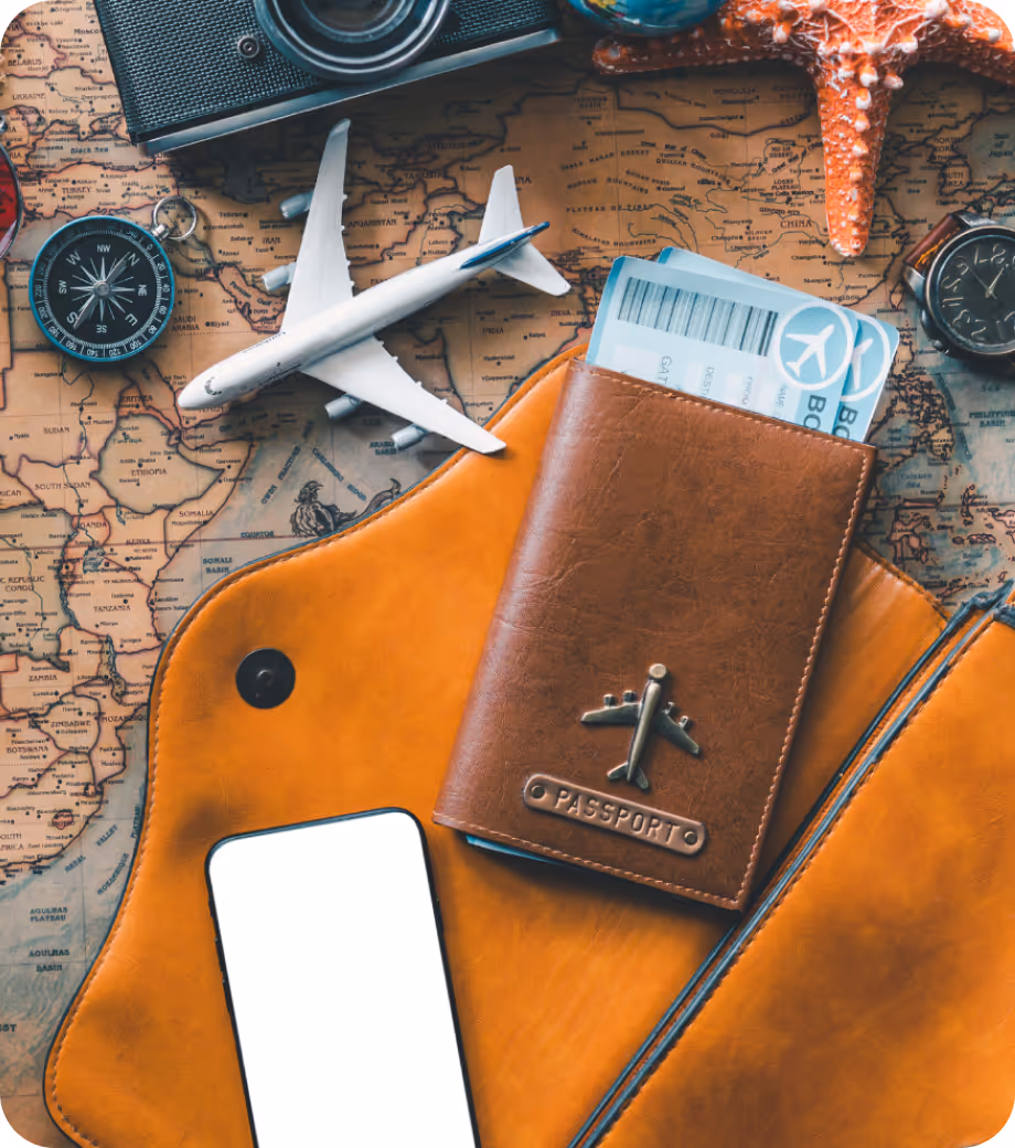 Overhead view of a travel setup with a passport in a leather holder, a smartphone, a toy airplane, a camera, and a map, symbolizing international travel planning.