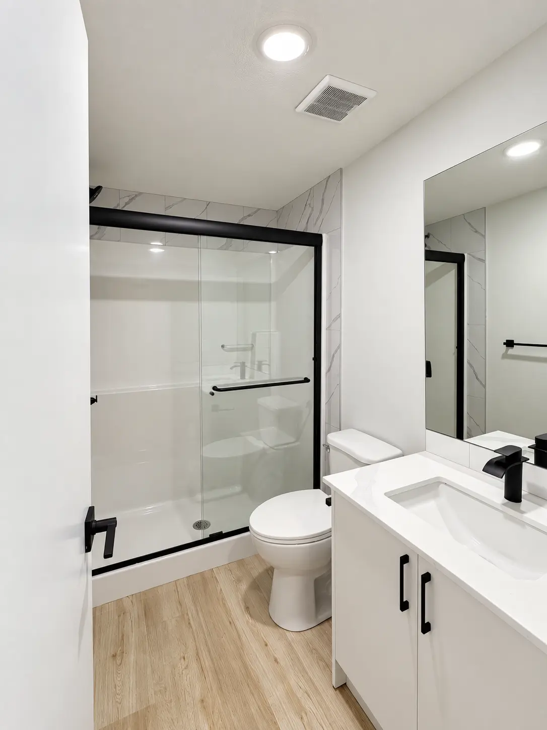 Bathroom with glass shower and quartz vanity at Saddlepeace Village