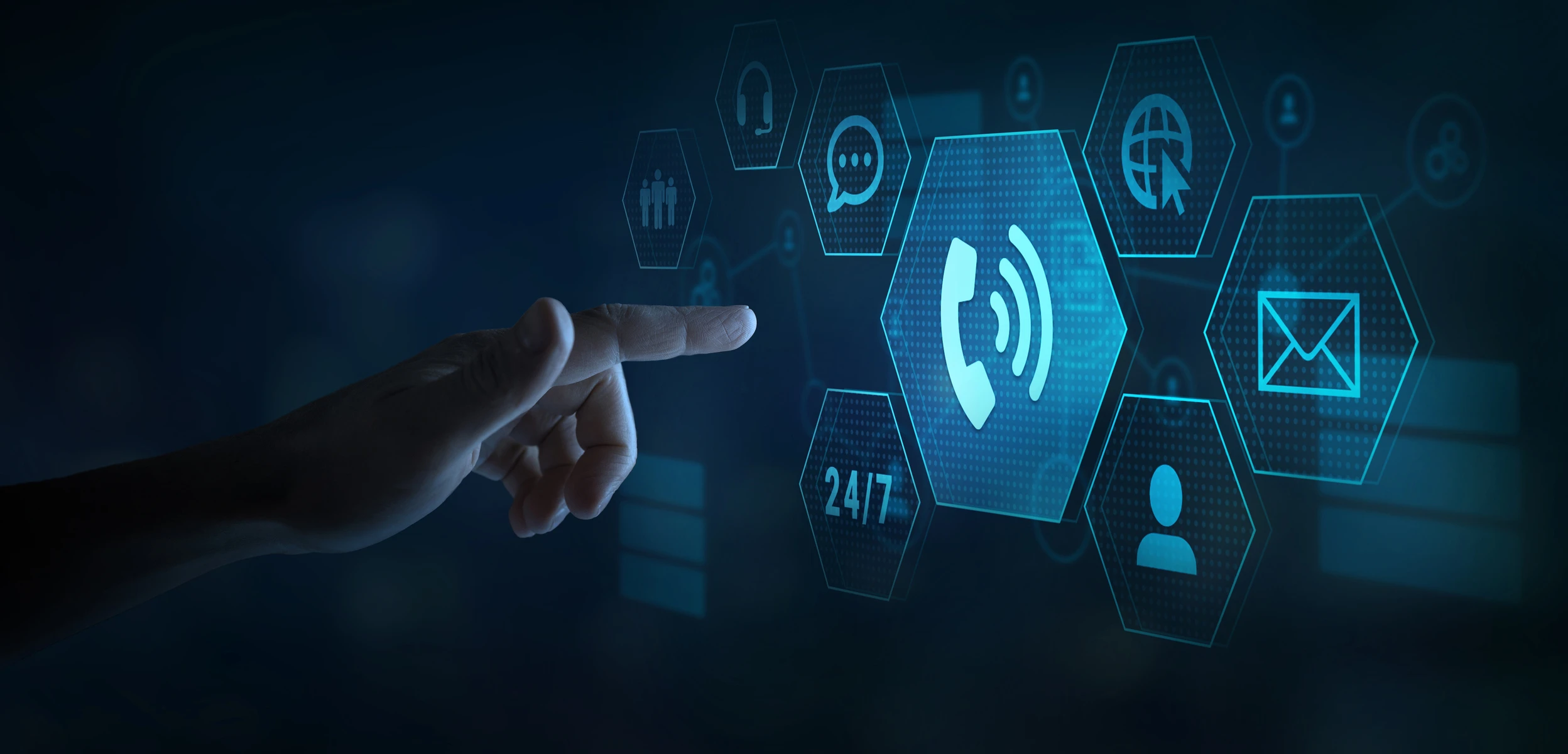 Hand pointing towards floating digital hexagon icons representing communication, including phone, email, chat, and 24/7 support.
