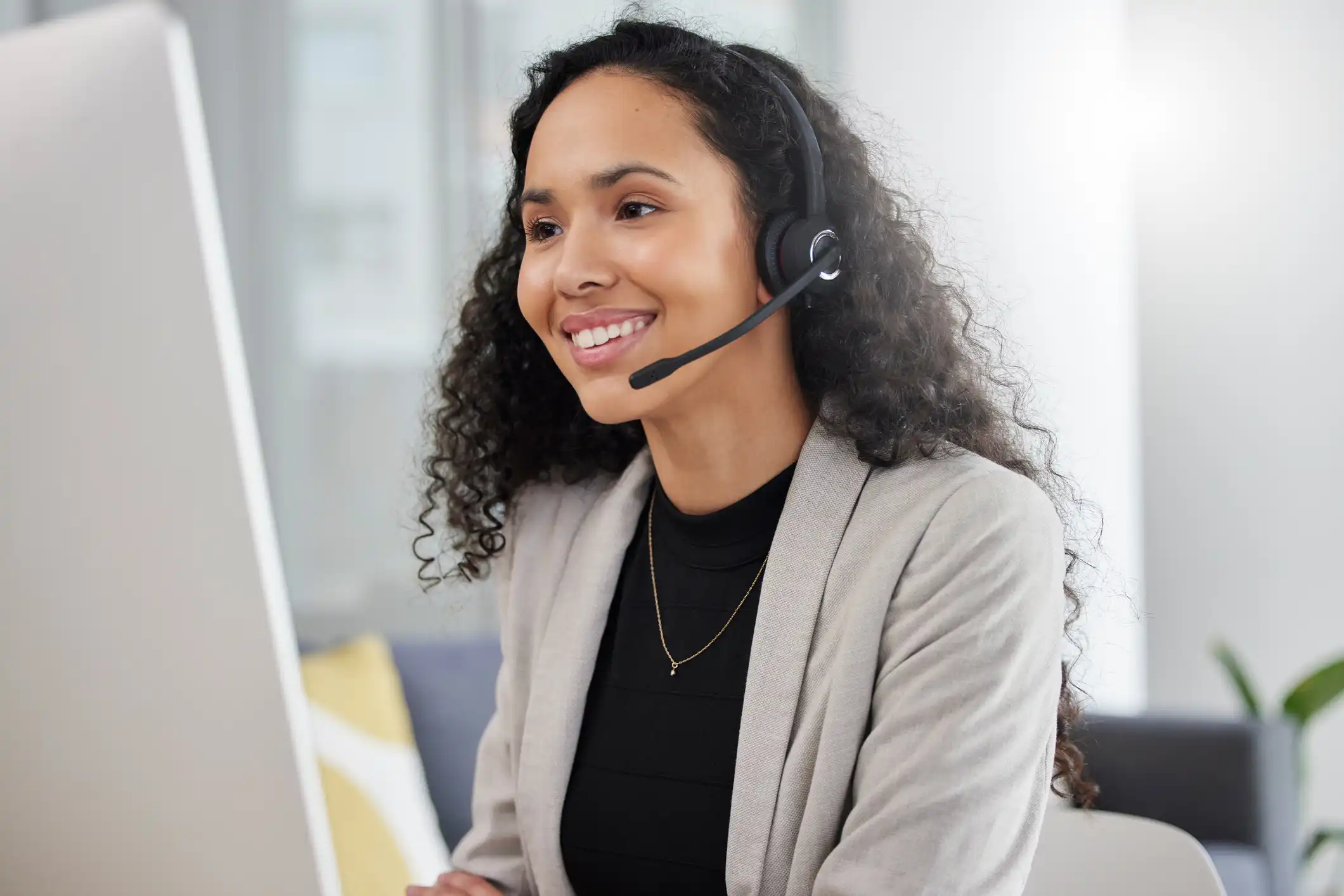 Customer service representative wearing a headset assisting a customer, representing AI-powered FNOL, claims intake, and insurance customer support.
