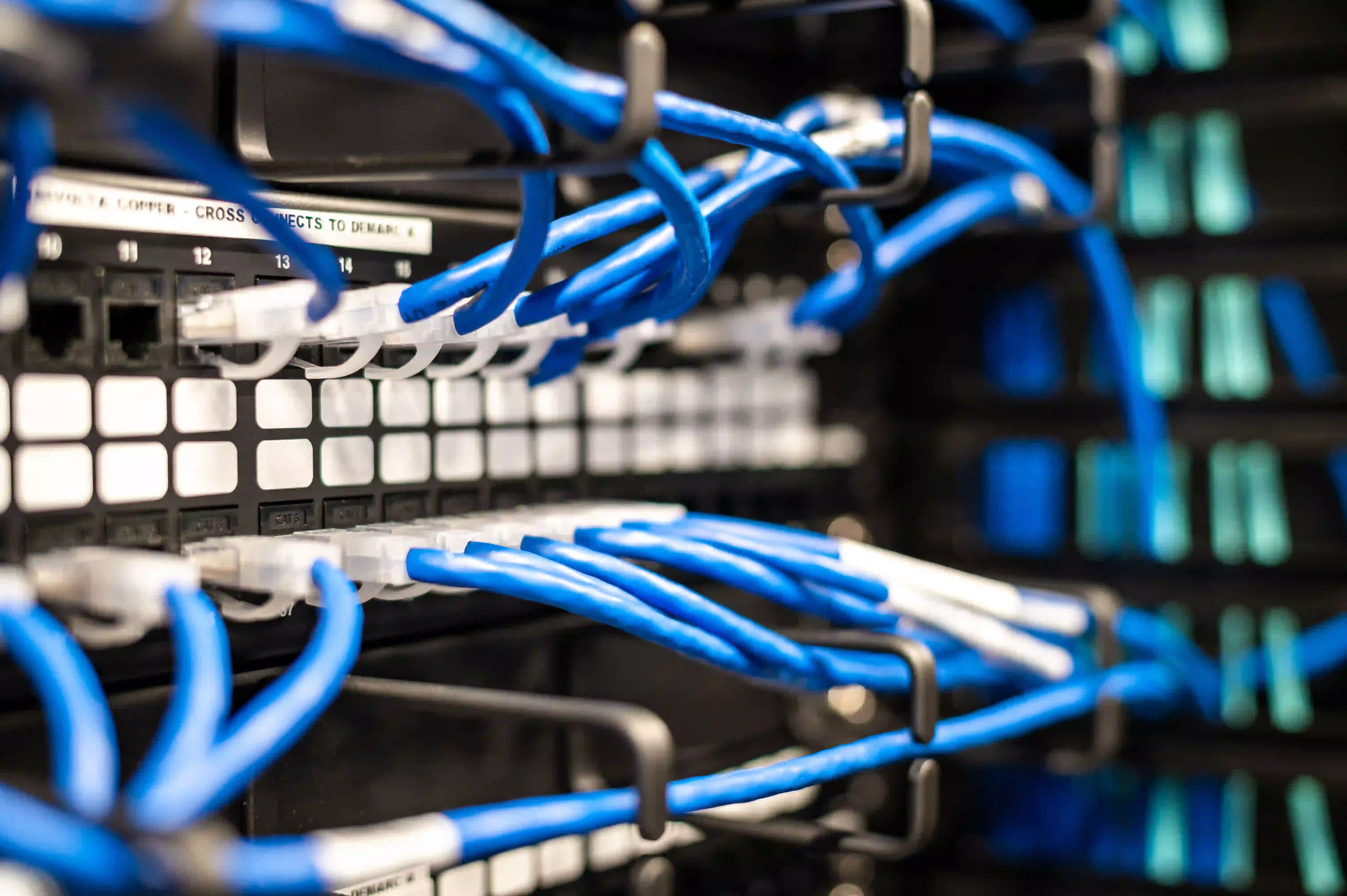 Network cables connected to Ethernet switches in a server rack.