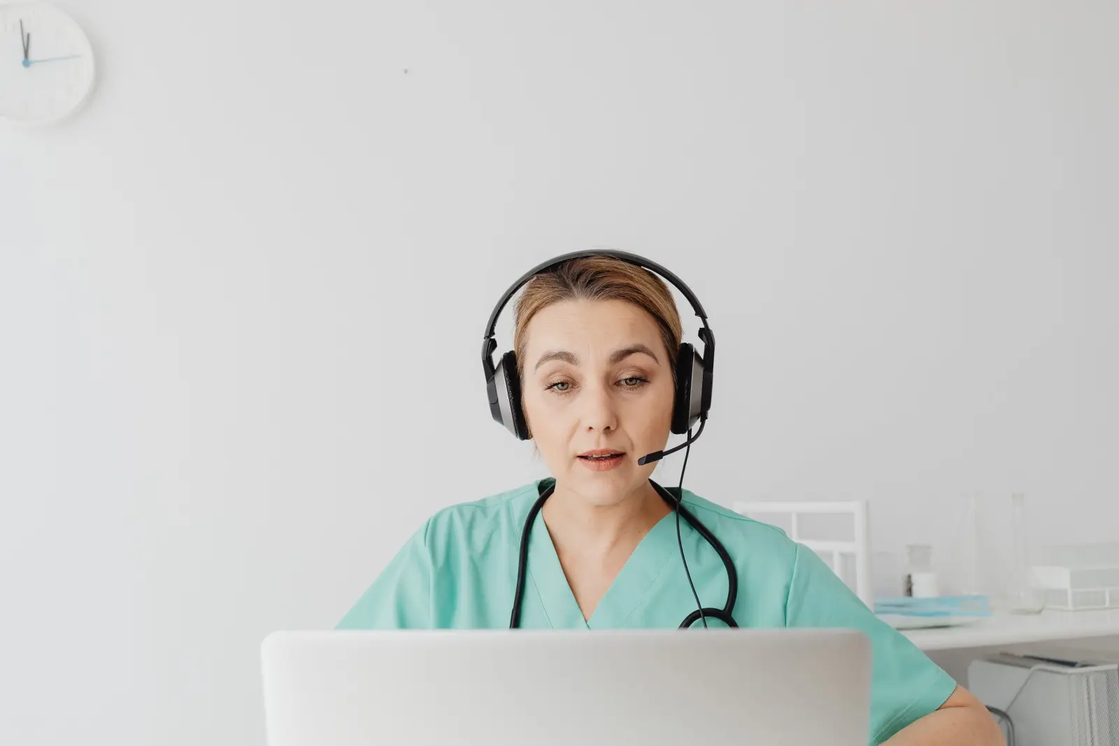 Woman wearing a headset and working at a computer in a healthcare setting