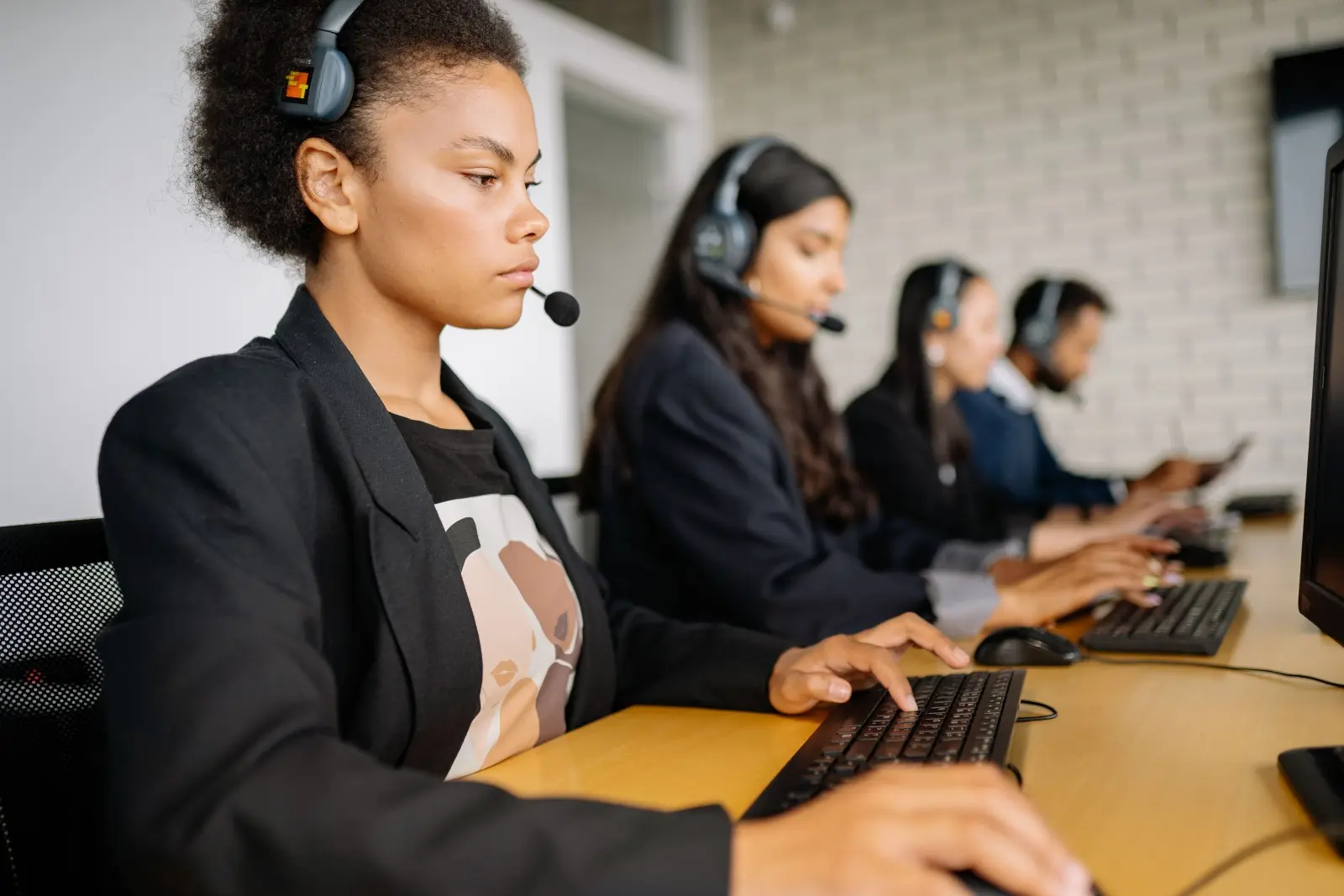 Customer service representative wearing a headset and working at a computer