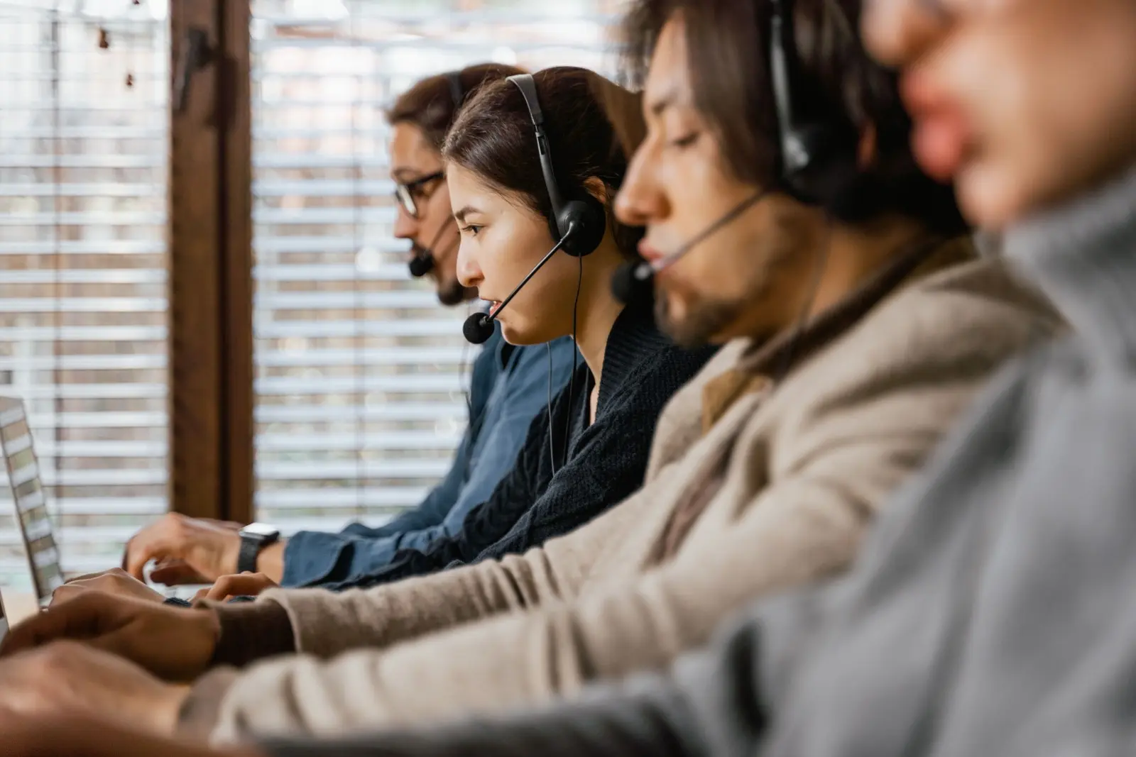 Customer support team members wearing headsets and working at computers