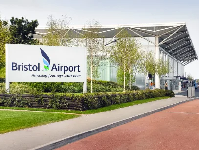 Bristol Airport entrance sign beside the terminal building and a red road surface
