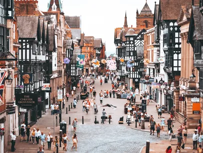 Busy pedestrian street lined with black-and-white timber-framed buildings in Chester