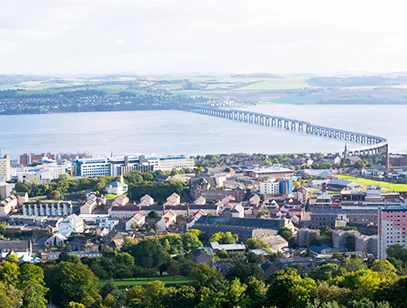 Rooftops of Dundee looking over the Firth of Tay towards the long railway bridge crossing the water