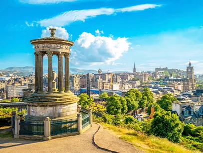 Edinburgh skyline from Calton Hill, with a columned monument in the foreground and the old town beyond